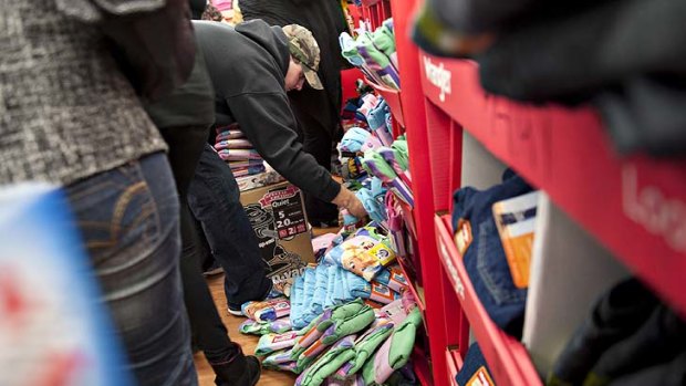 A bin of $4.47 childrens pyjamas spills onto the floor as shoppers work themselves into a frenzy at a Wal-Mart in Ohio.