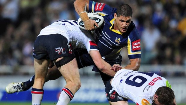 Willie Mason of the Cowboys is tackled by Mitch Aubusson and James Aubusson of the Roosters in 2010.