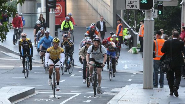 Cyclist ride into Sydney in the morning rush, using the bike lane in King Street.
