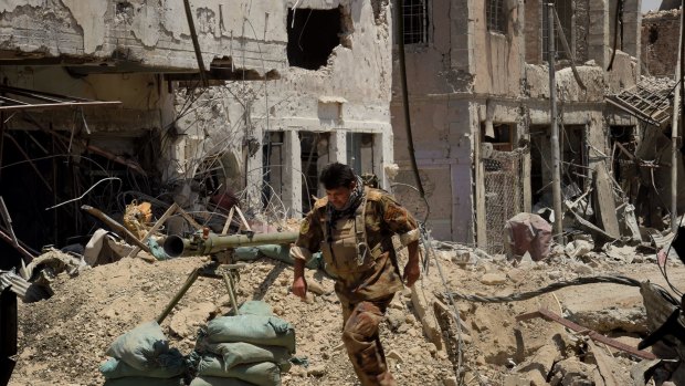 Lieutenant-Colonel Saeed Bader Kathem moves away from the blast range of a planned detonation of one of six IEDs on a road in West Mosul.