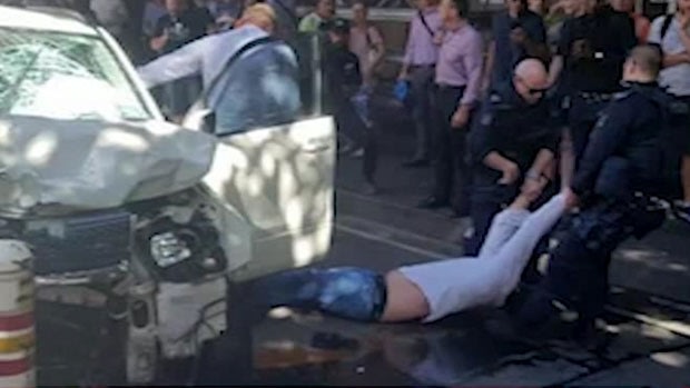 A man is dragged from a car in Flinders Street after an attack that left 18 people injured. 