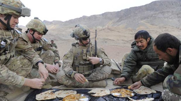 Australian soldiers at a breakfast meeting with Afghan army counterparts discuss a patrol in Oruzgan province.