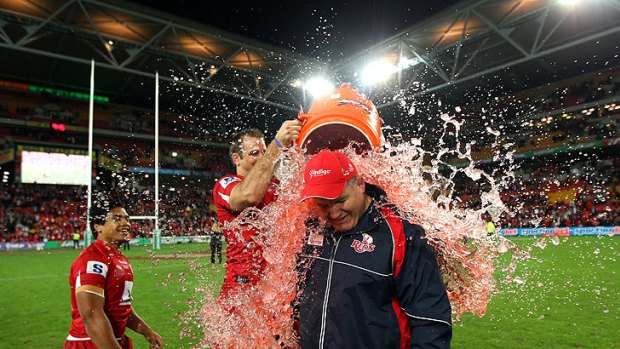 Queensland Reds players douse coach Ewen McKenzie after last year's Super Rugby final.