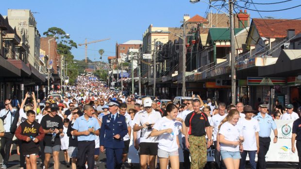 Thousands make their way down Coogee Bay Road as part of a walk in support of White Ribbon Day.