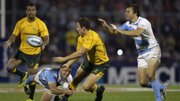 Mike Harris offloads to Kurtley Beale despite the tackle by Santiago Fernandez.