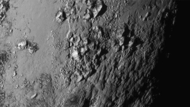 A close-up image of a region near Pluto's equator reveals ice mountains.