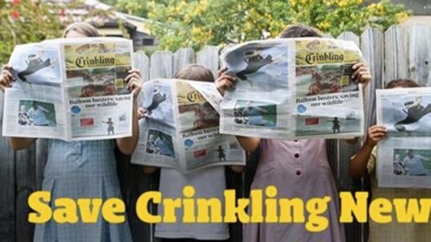 Schoolchildren hold up copies of the <em>Crinkling News</em> in an image from the newspaper's Twitter page.