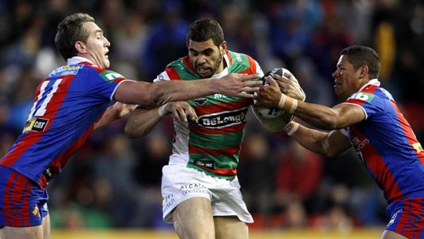 Double team ... Greg Inglis flanked by Newcastle's Chris Houston and Dane Gagai.