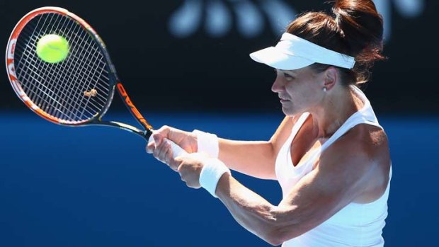 Casey Dellacqua plays a backhand against Zheng Jie of China.