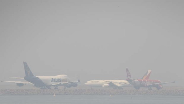 Heavy smoke blankets Sydney airport after days of fires .