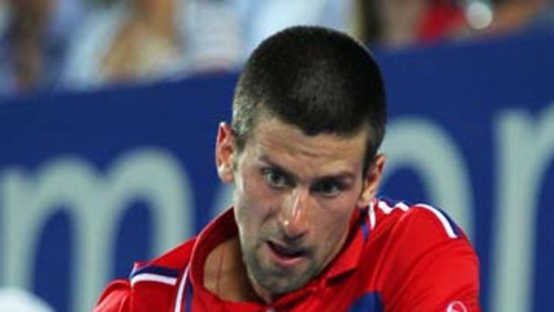 Novak Djokovic returns against Lleyton Hewitt in the Serbia-Australia Hopman Cup clash last night.