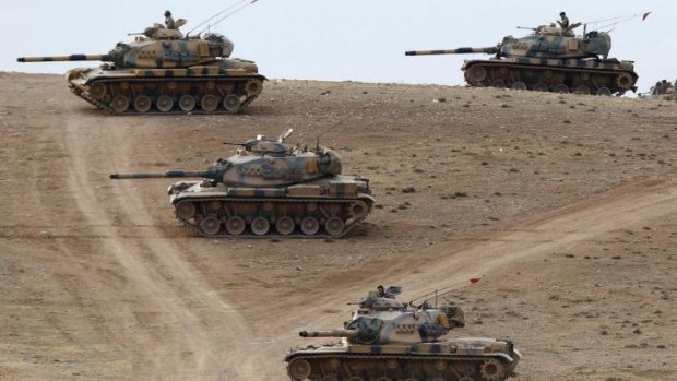 Turkish army tanks take up position on the Turkish-Syrian border.