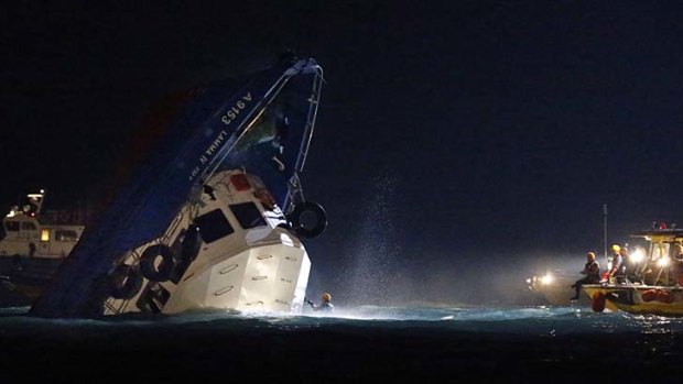 Rescuers check on a half submerged boat after it collided Monday night near Lamma Island, off the southwestern coast of Hong Kong Island.