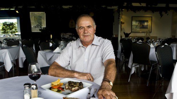 Theo Papoulias with the roast lamb which has been served at Hellenic Club in Sydney since 1959.