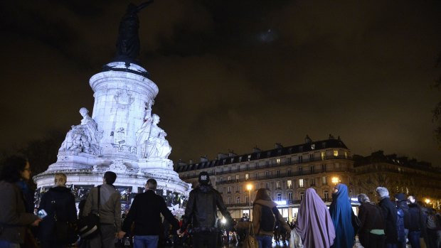 People make a chain on Republic Square on Friday to mark a week since the Paris attacks.