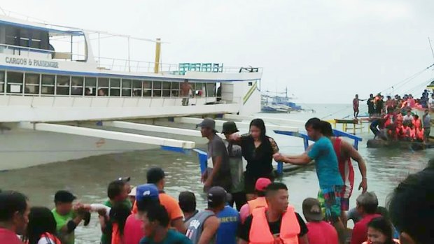 Rescued passengers from the ill-fated M/V Mercraft 3 disembark from a rescue boat.