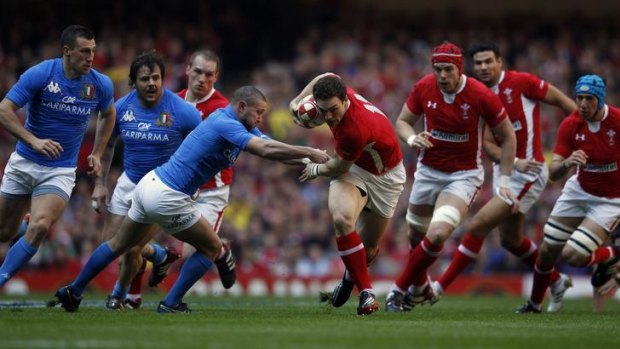 George North breaks free from a tackle by Italy's Fabio Semenzato.