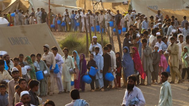 Pakistanis who have fled the fighting between the military and Taliban queue for food at a refugee camp in Swabi.