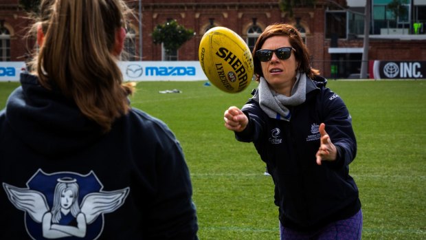 Bridie O'Donnell gets tips at a footy clinic for women at Arden Street Oval.