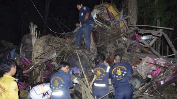 Horrific scene ... Thai emergency workers sift through the wreckage of a passenger bus after an accident in Mae Sot, northern Thailand.