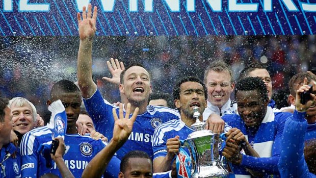 Chelsea players celebrate with the trophy.