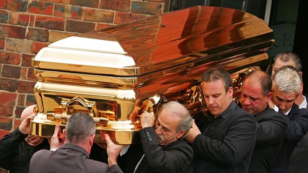 The gold coffin containing convicted drug trafficker and murderer Carl Williams is carried by pallbearers at his funeral in April 2010.