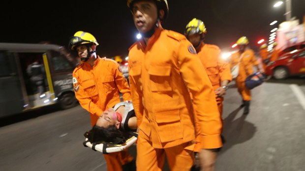 An anti-impeachment demonstrator is carried on a stretcher by rescue workers after being overcome by police pepper spray at a demonstration in Brasilia on Wednesday.