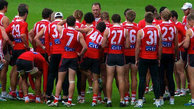 Winning solves everything: Swans coach John Longmire (centre) addresses his players on Tuesday at the SCG.