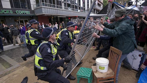 Police scuffle with protesters trying to barricade themselves inside the makeshift camp.