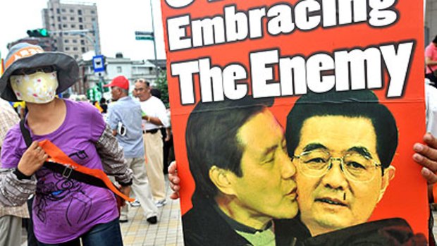 A protester holds a placard depicting Taiwan’s President Ma Ying-jeou and Chinese President Hu Jintao during a protest last Saturday in Taipei.