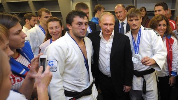 Russian President Vladimir Putin, centre right, poses for a photo with athletes while attending the Judo World Cup in the city of Chelyabinsk in Siberia, Russia.