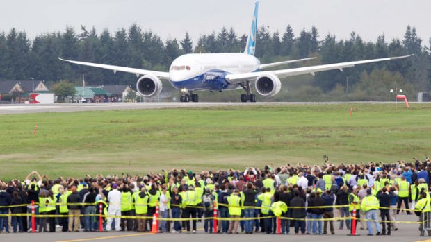 The Boeing 787-9 Dreamliner taxis on the runway in front of a crowd of employees before its first flight.
