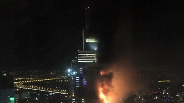 Smoke and flames pour out of a residential building as a fire runs up some 20 stories of the high rise in Dubai, United Arab Emirates on Thursday. 