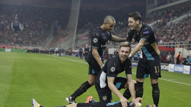 Nightmare: Arsenal fans celebrate their must-win victory over Olympiakos, but now face Barcelona.