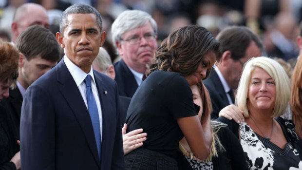 US first lady Michelle Obama comforts a family member during a memorial service for victims of the Washington Navy Yard shooting.