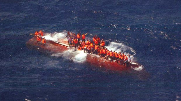 Refugees sit on the SIEV 358 asylum seeker boat after it capsized last year.