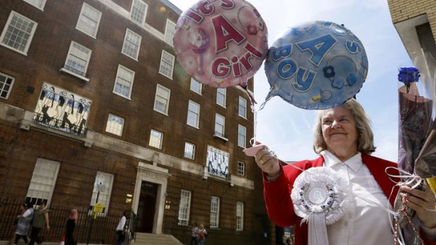 Royal supporter Margaret Tyler displays balloons for the media in front of the Lindo Wing at St Mary's Hospital in London.