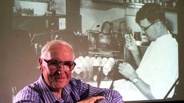 Professor Frank Fenner in front of a projected photograph of himself taken in the 1950.