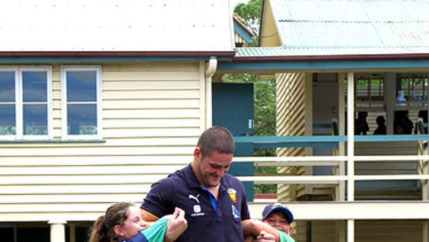 The Lion and the cubs ... Brendan Fevola plays with Sunshine Coast students.