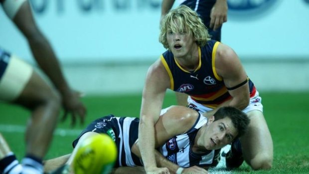 Andrew Mackie has eyes only for the ball as Rory Sloane of the Crows watches on.