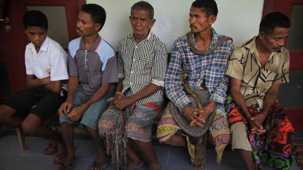 East Timorese men wait to be examined.