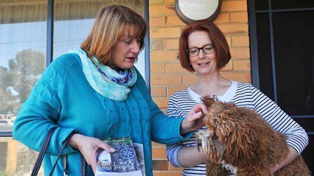 Joanne Ryan greets former PM Julia Gillard at her home. Rueben the cavoodle approves.
