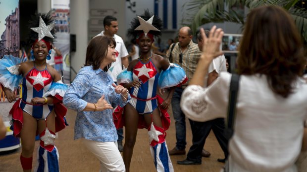 An unidentified passenger of Carnival's Adonia cruise ship dances with a couple of Cuban entertainers, as locals welcome cruise passengers on Monday.
