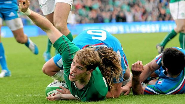 Andrew Trimble evades a tackle by Italy's flanker Joshua Furno to score a try.