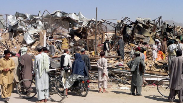 Onlookers at the site of the bomb blast in Kandahar that reduced a city block to rubble and killed   more than 40 people and wounded more than 60.