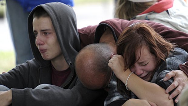 Kent Manning (left) and his sister Libby are comforted by their father after hearing there was no hope of finding their mother.