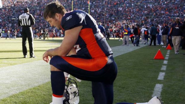 ''Leading in the trenches'' &#8230; Tim Tebow prays before Denver's game against Chicago last weekend.