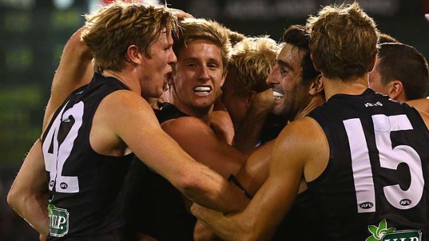 Energised: Port Adelaide players celebrate their come-from-behind win over West Coast.