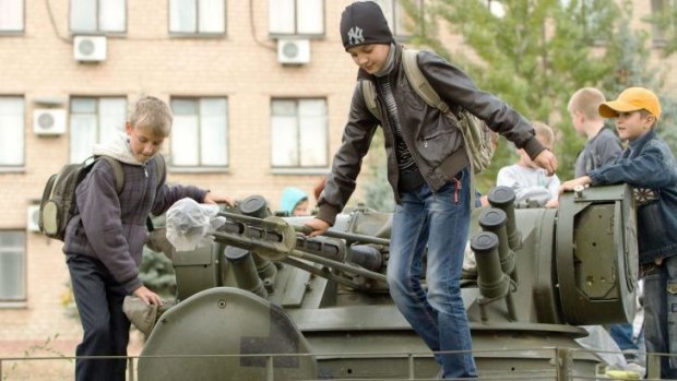 Child's play: With truce talking continuing, kids turn a silent tank into a playground in Soledar. 