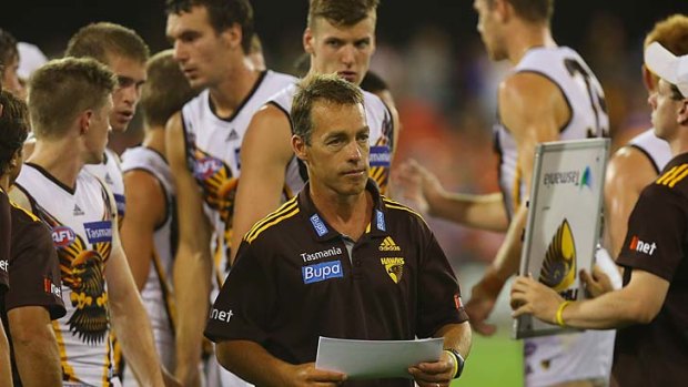 Hawks coach Alastair Clarkson leaves the field after talking to players at half-time.